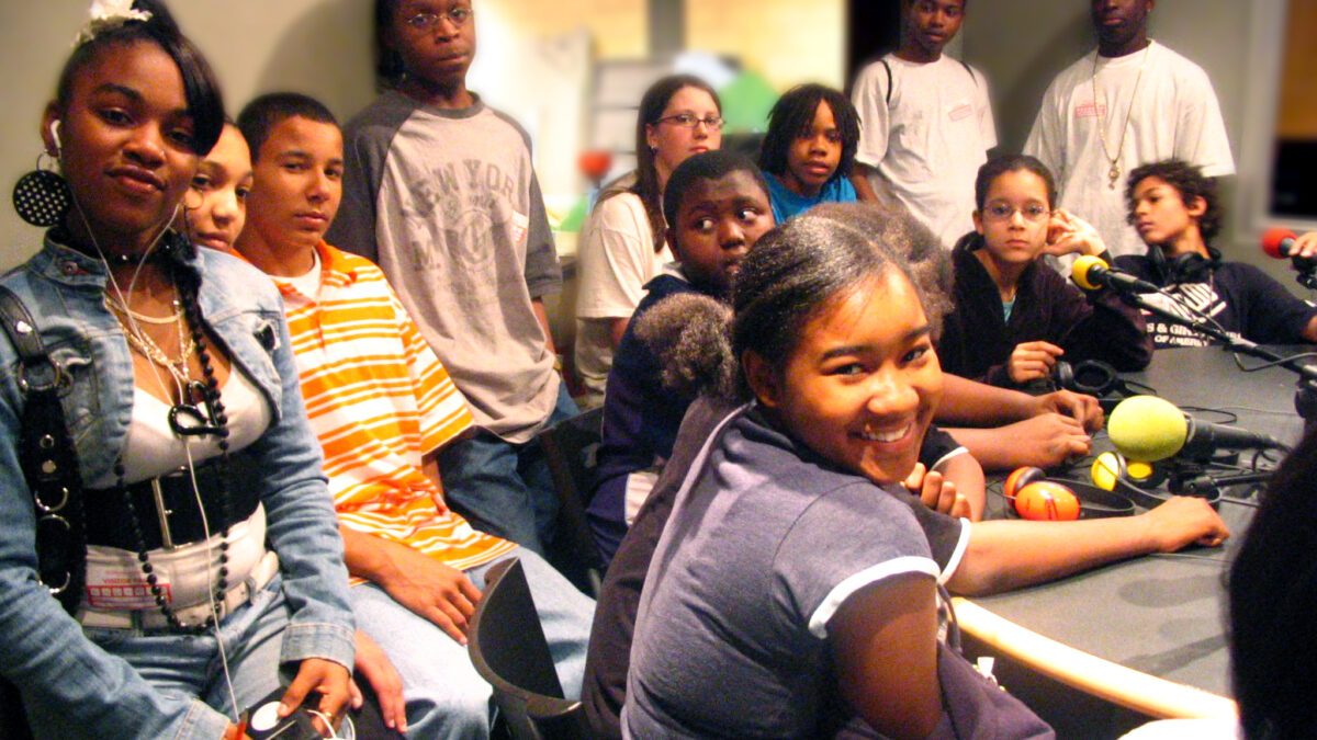 Manchester Academic Charter School Graduation 2007 Twelve youth sitting around microphones on a table in a radio studio
