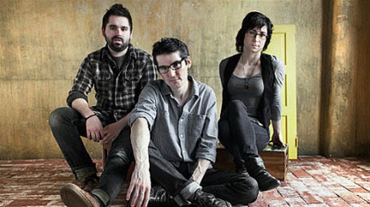 Three adults sitting and posing in profile