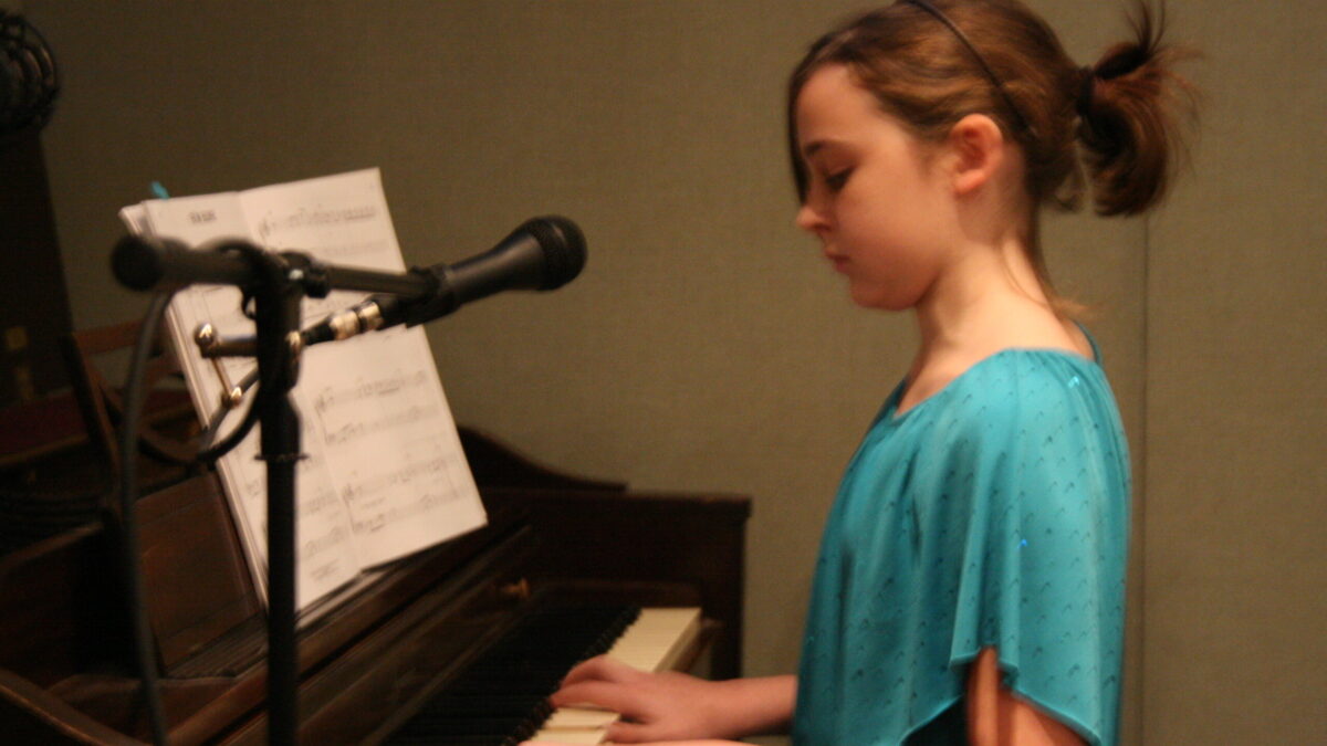 A youth playing a piano in a radio studio