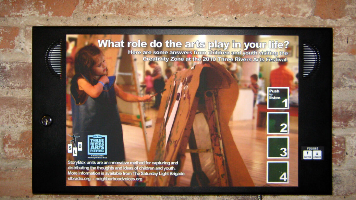 An image of a youth interacting with a wooden device on a brick wall