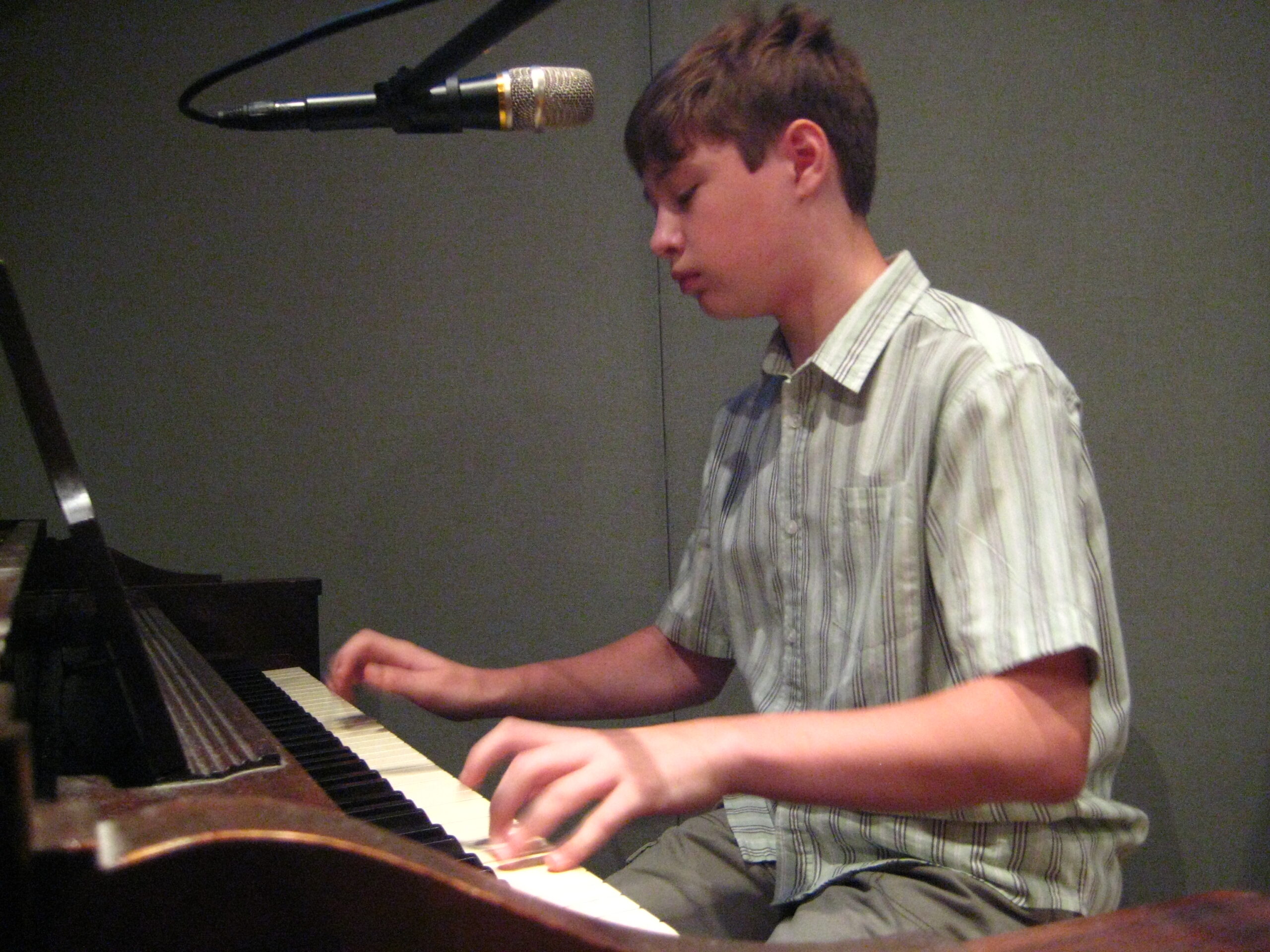 A youth playing a piano in a radio studio