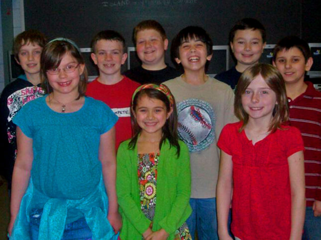 Nine youth smiling and standing in profile