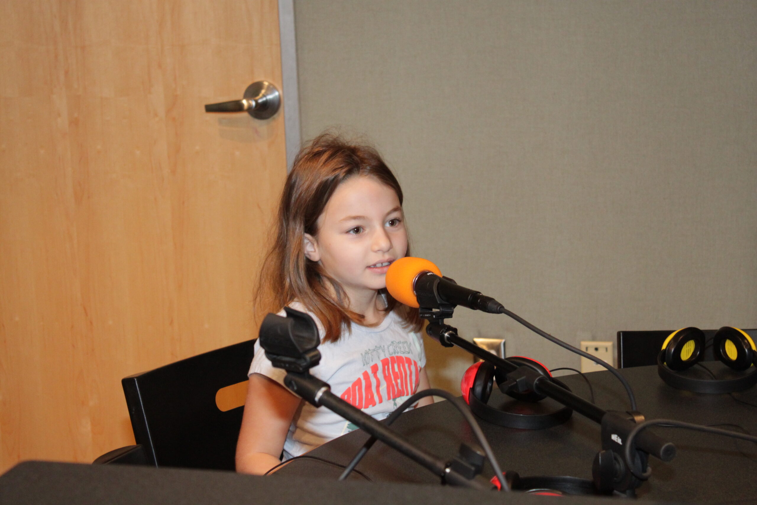 A youth singing into a microphone in a radio studio
