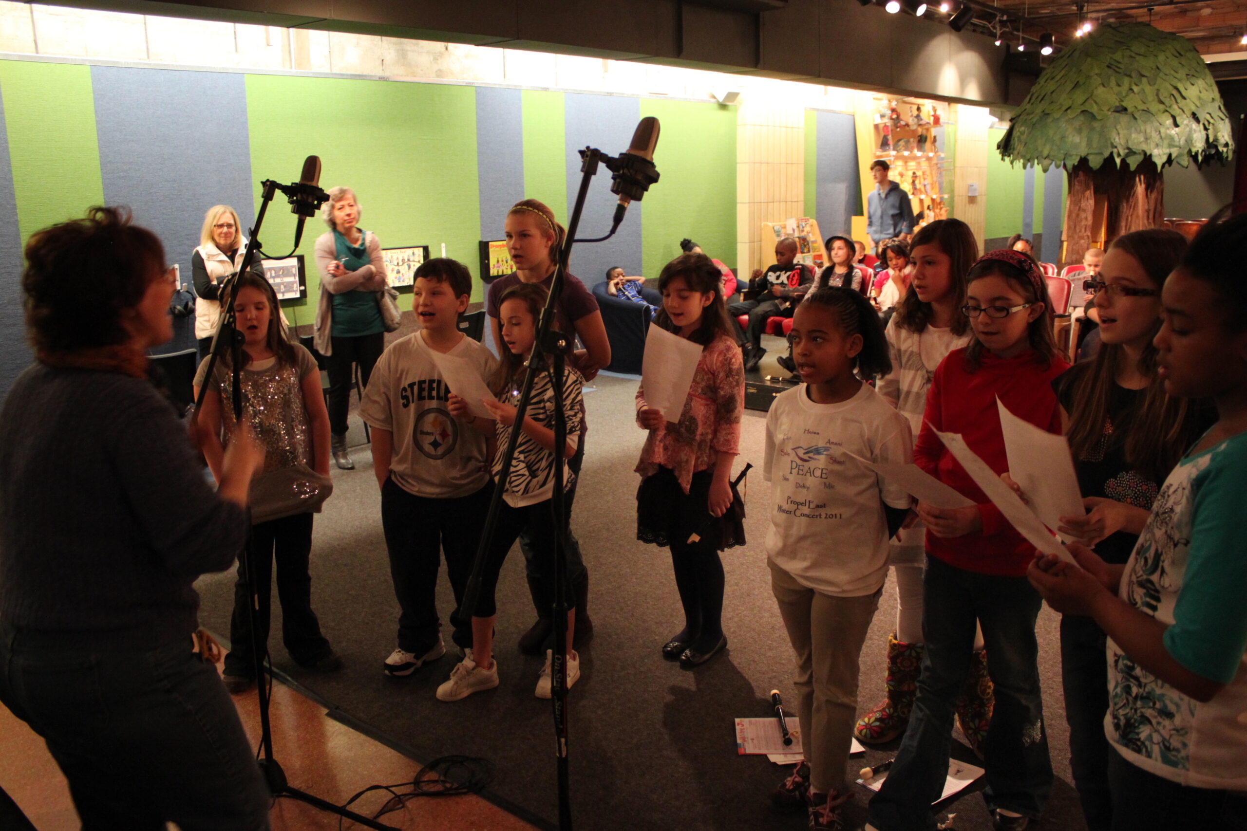 Ten youth singing in a choir led by an adult