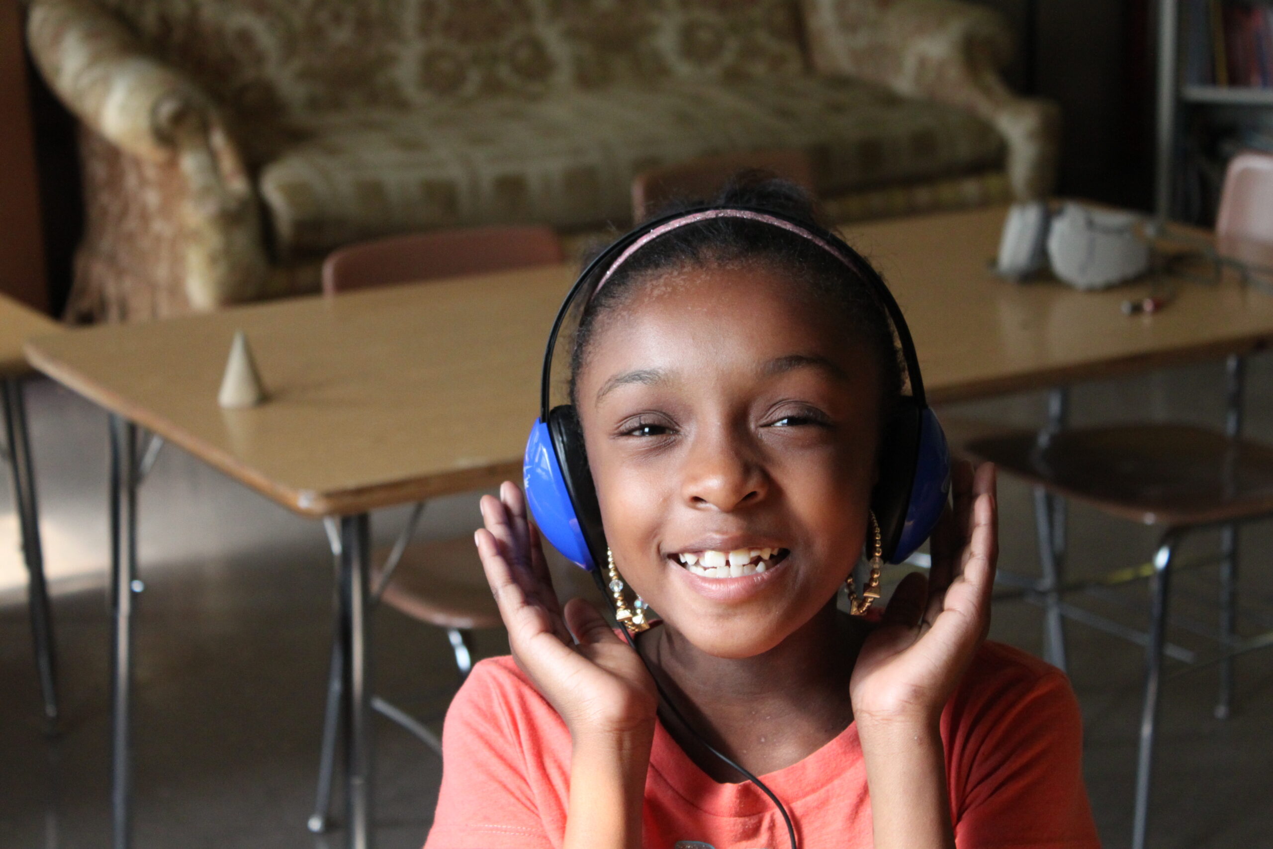 A youth wearing headphones smiling at the camera