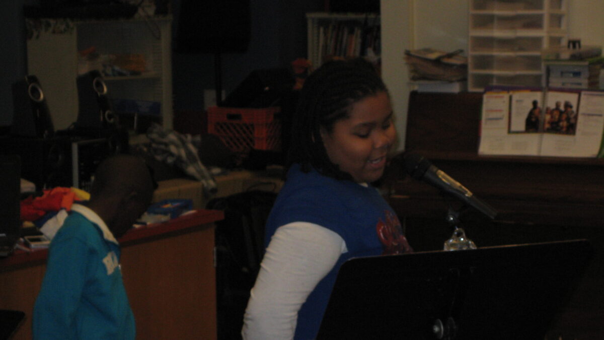 Pittsburgh Spring Hill 2013 A youth looking backwards at a podium and a youth speaking into a microphone while looking at a music stand