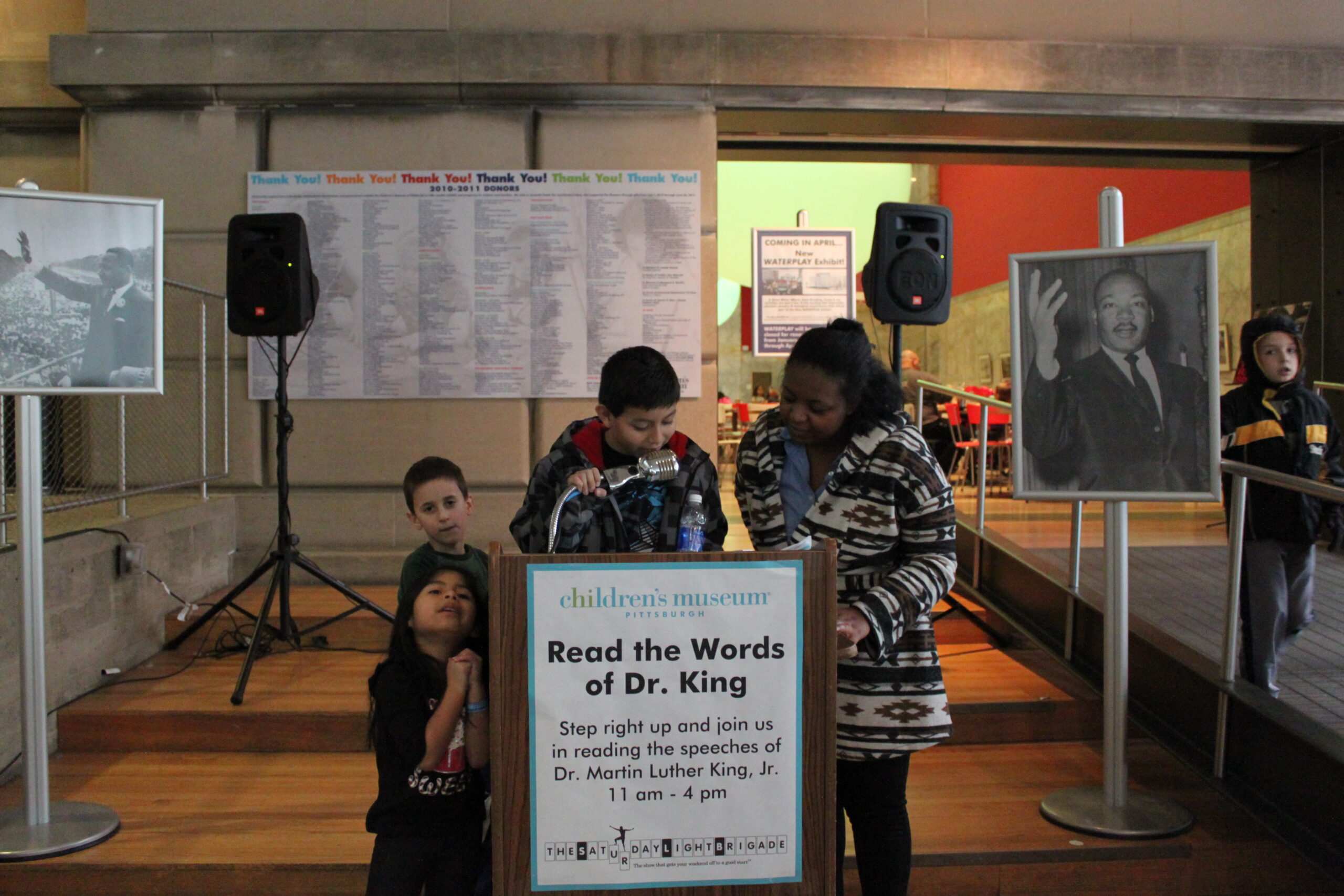 Four youth standing at a podium in front of two speakers