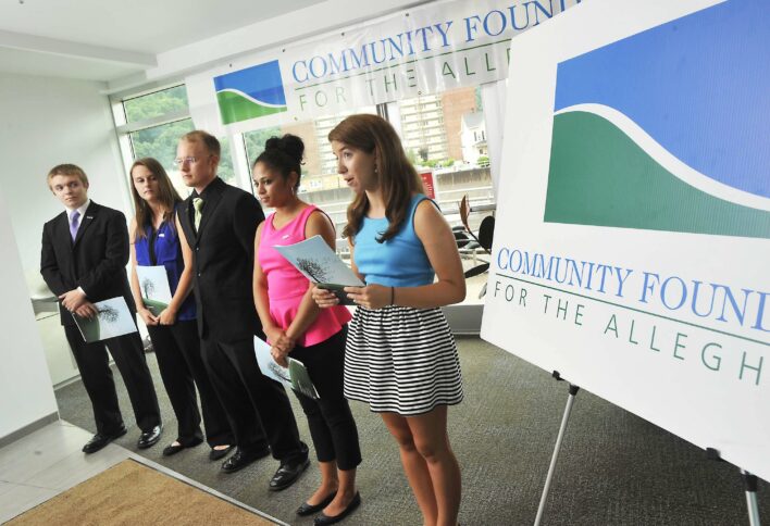 Five teens speaking in front of posterboards advertising the Community Foundation of the Alleghenies