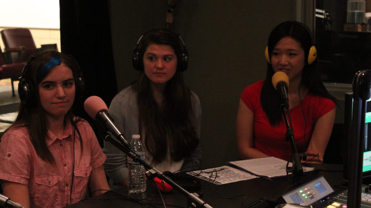 IMG_8527 Three teens wearing headphones speaking into microphones in a radio studio
