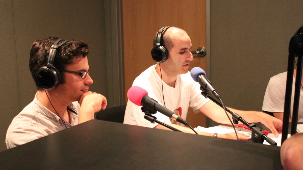 IMG_1332 Two adults wearing headphones speaking into microphones in a radio studio