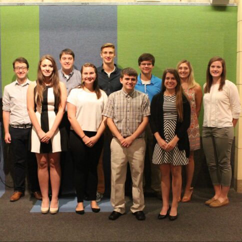 Ten teens smiling while standing in profile