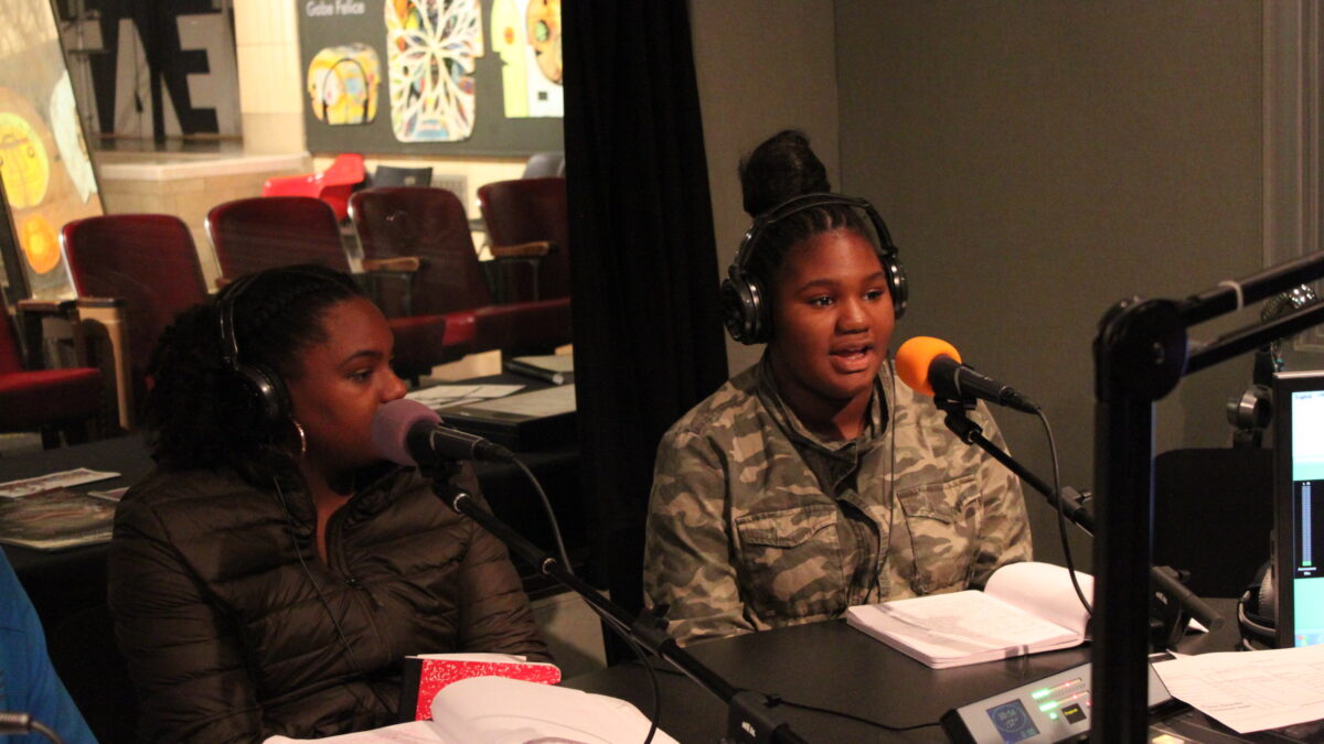 img_2093 Two youth wearing headphones speaking into microphones in a radio studio