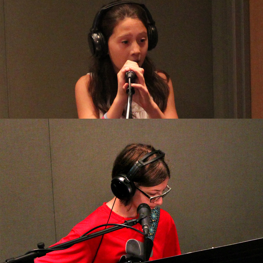 A youth wearing headphones singing into a microphone and a youth wearing headphones playing an electric guitar in a radio studio