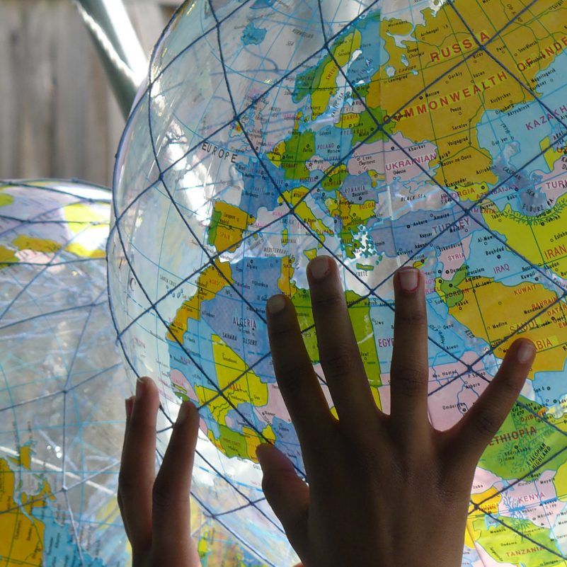 Two hands holding part of an inflatable globe