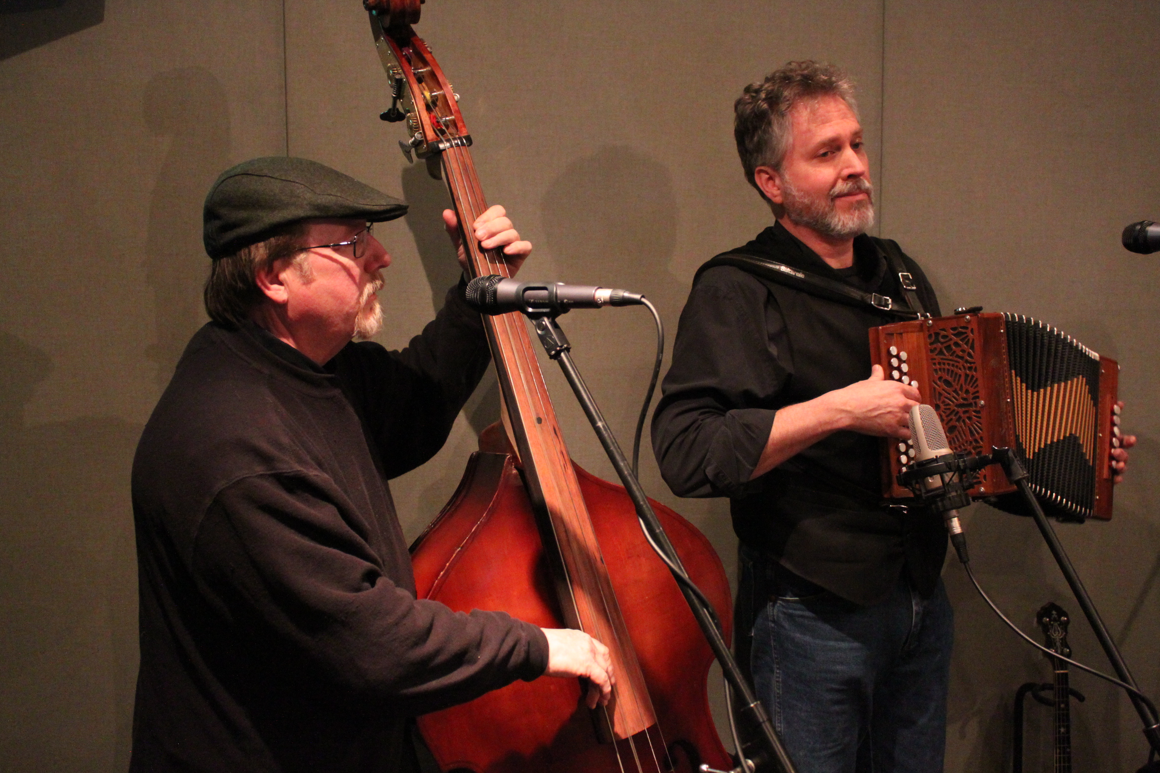 An adult paying upright bass and an adult playing accordion in a radio studio