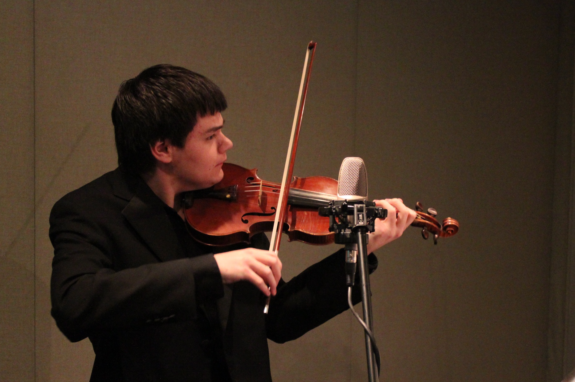 A teen playing violin in a radio studio