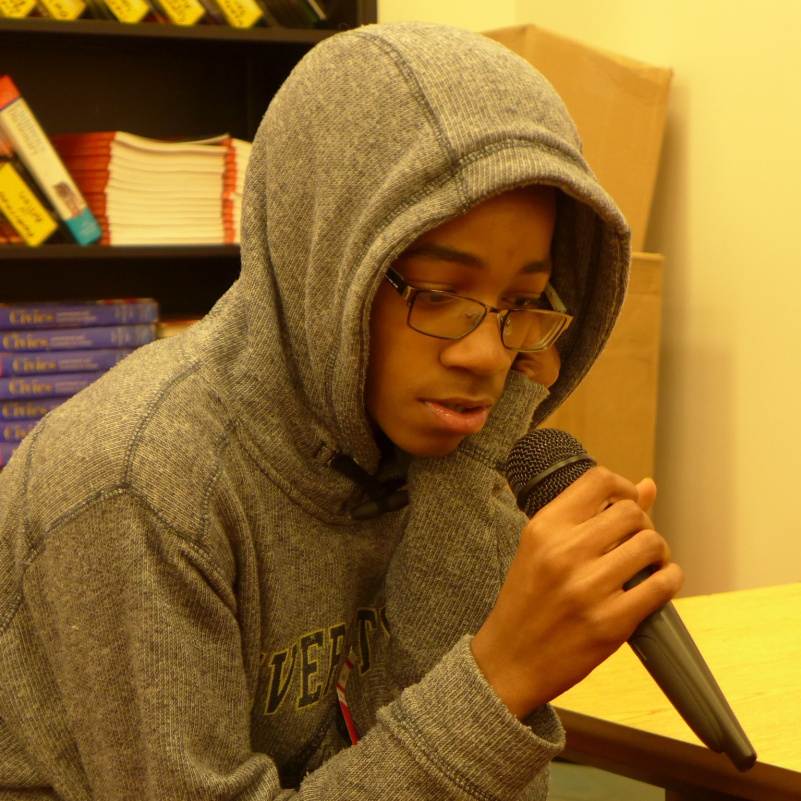 A teen holding a microphone in a classroom