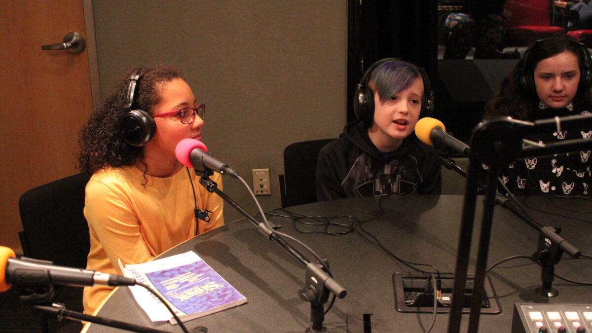 IMG_3231 Three youth wearing headphones speaking into microphones in a radio studio
