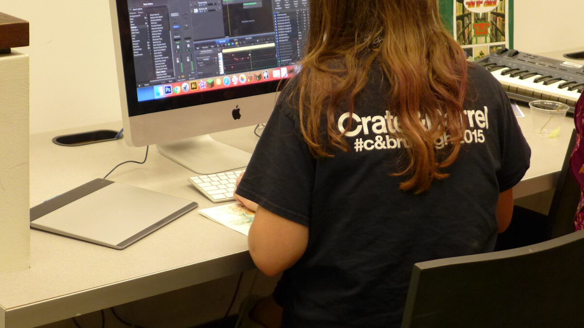 An individual looking at audio editing software on a Macintosh computer