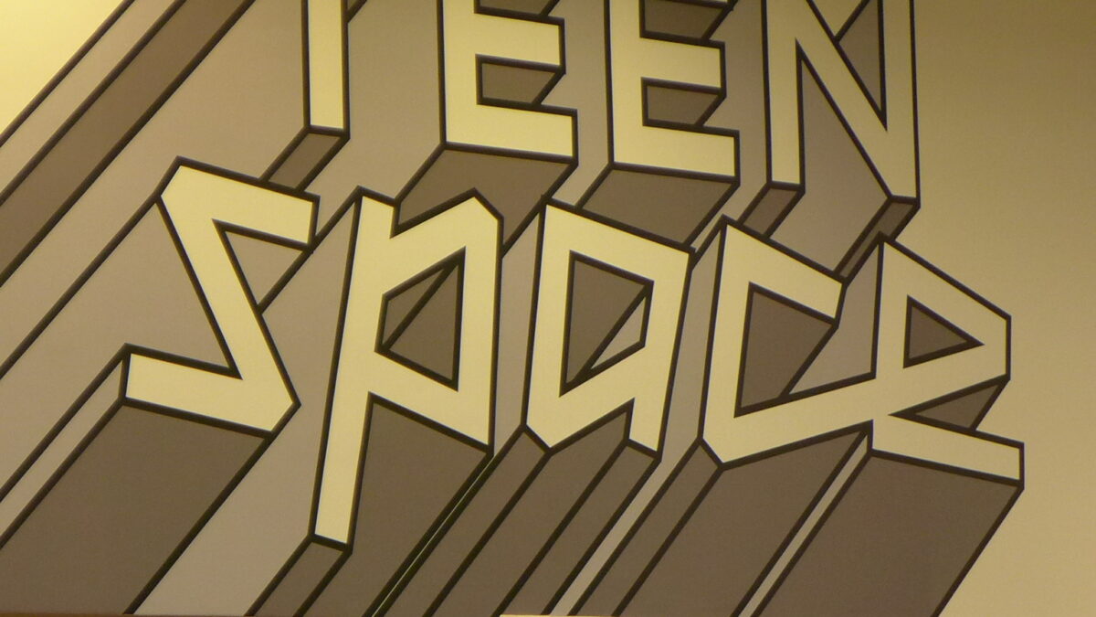 The text "Teen space" written in blocky gray font on a white wall