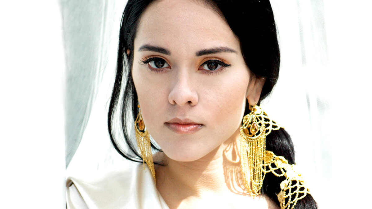 An adult wearing a white shirt posing in profile