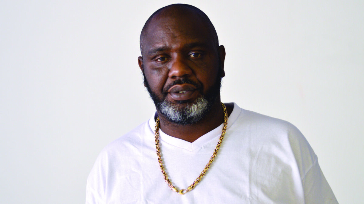 An adult wearing a white shirt posing in profile