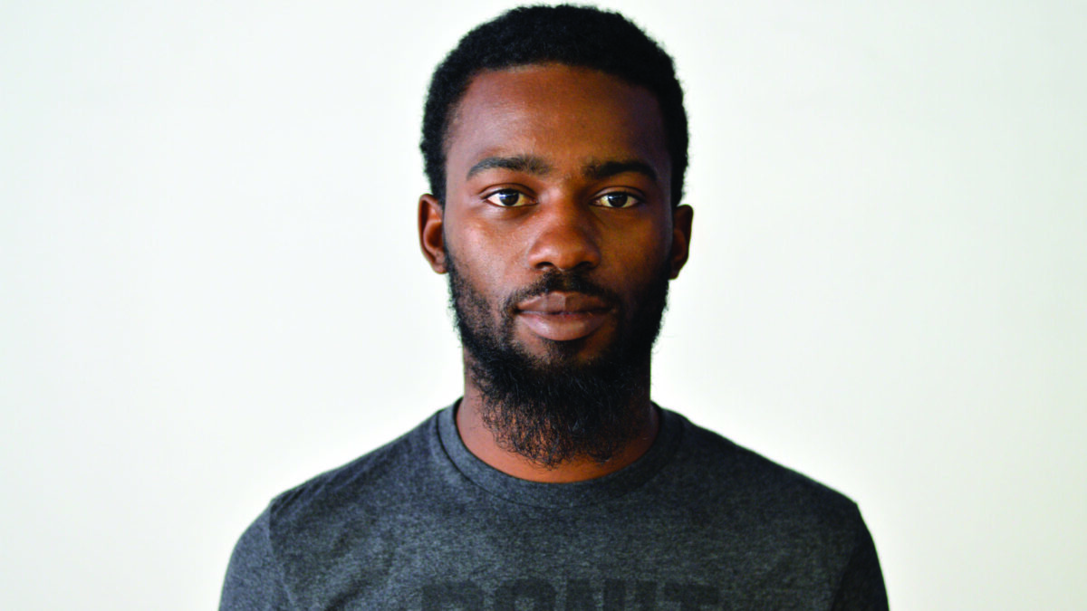 An adult wearing a gray shirt posing in profile