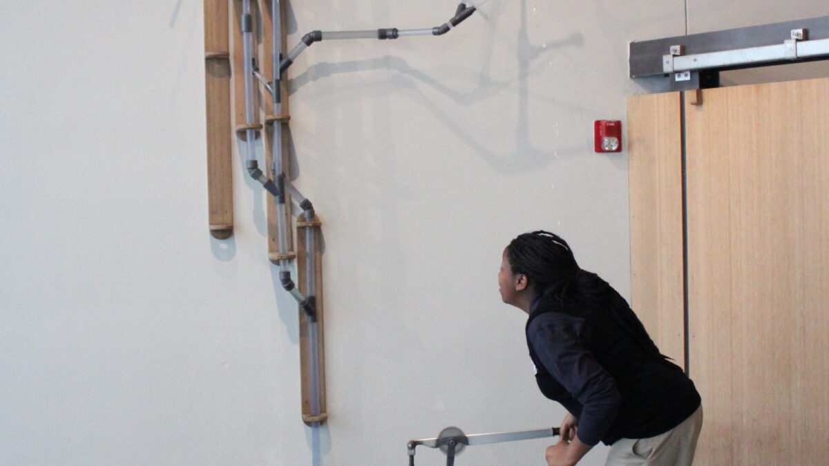 A teen interacting with a wiry museum exhibit