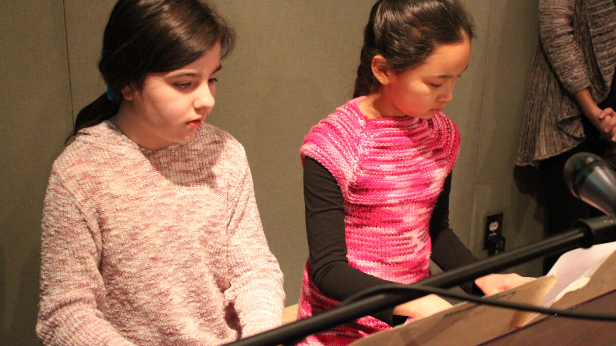 Two youth playing a piano keyboard in a radio studio