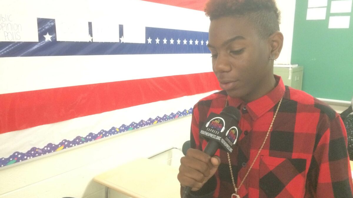 A youth holding a microphone in a classroom