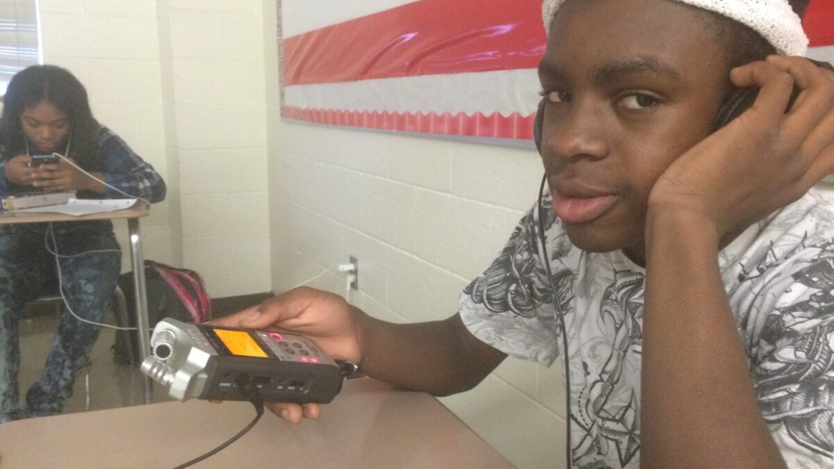 Two youth interacting with portable recorders in a classroom
