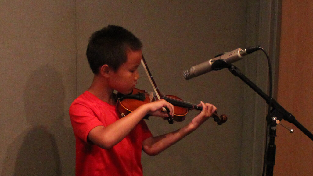 IMG_4293_1 A youth playing violin into a microphone in a radio studio
