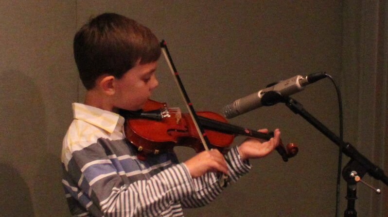 IMG_4297_1 A youth playing a violin into a microphone in a radio studio