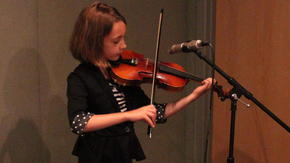 IMG_4300_1 A youth playing violin into a microphone in a radio studio
