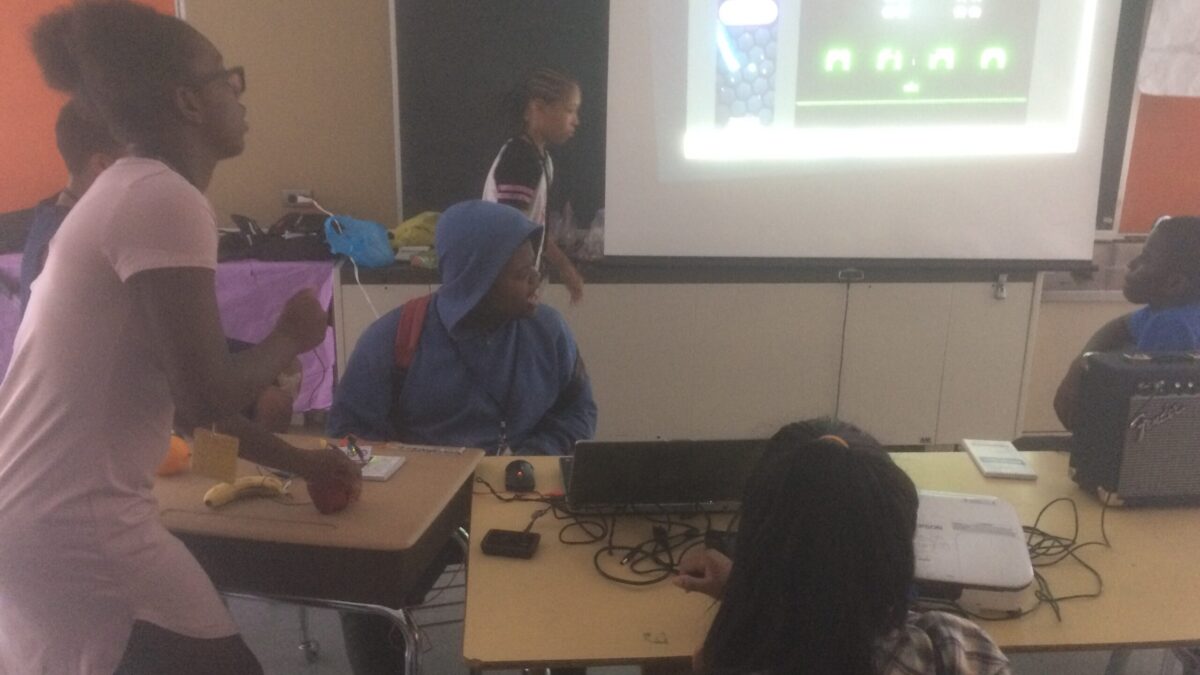 Four youth looking at a projected screen in a classroom