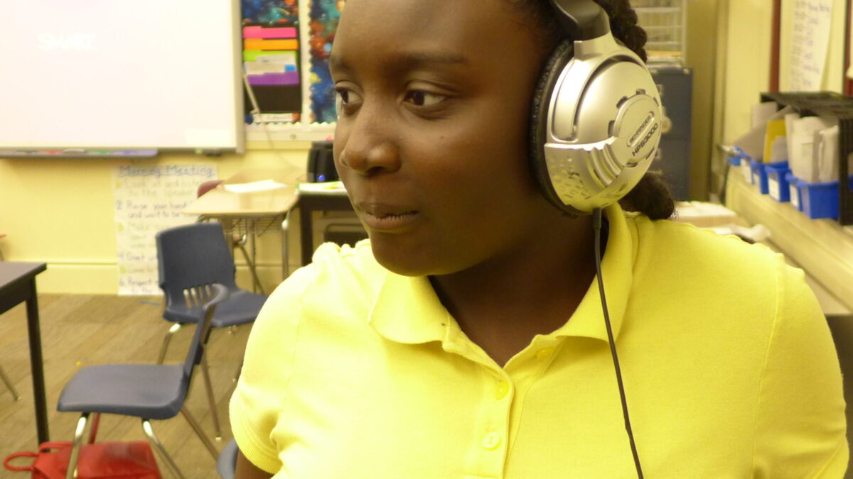 A teen wearing headphones in a classroom