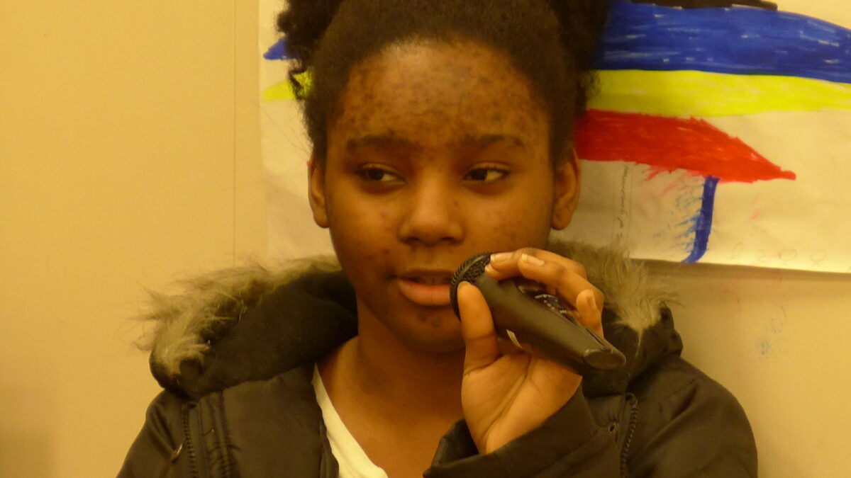 A youth holding and speaking into a microphone