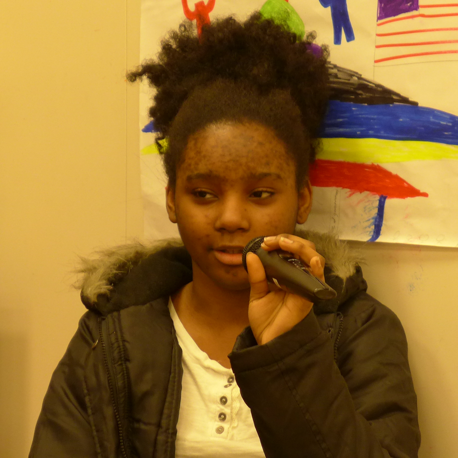A youth holding and speaking into a microphone