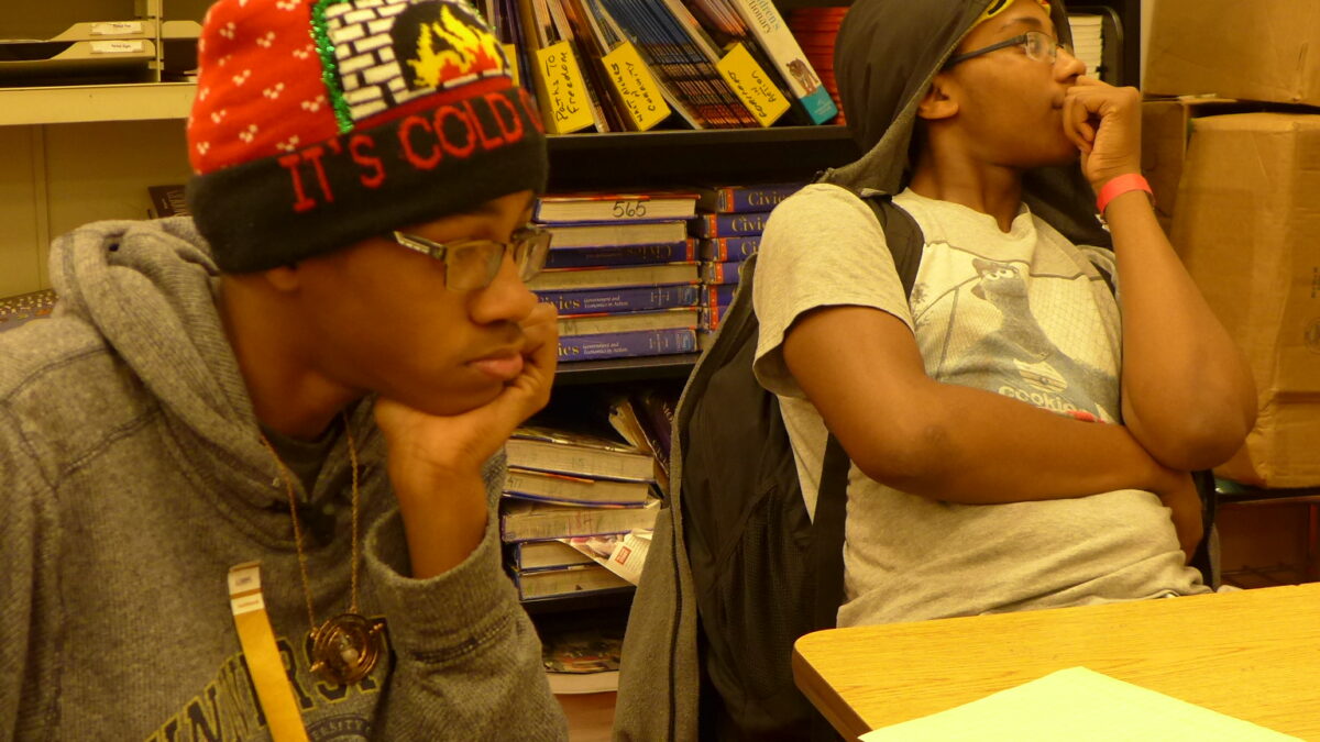 Two youth sitting around a table in a library