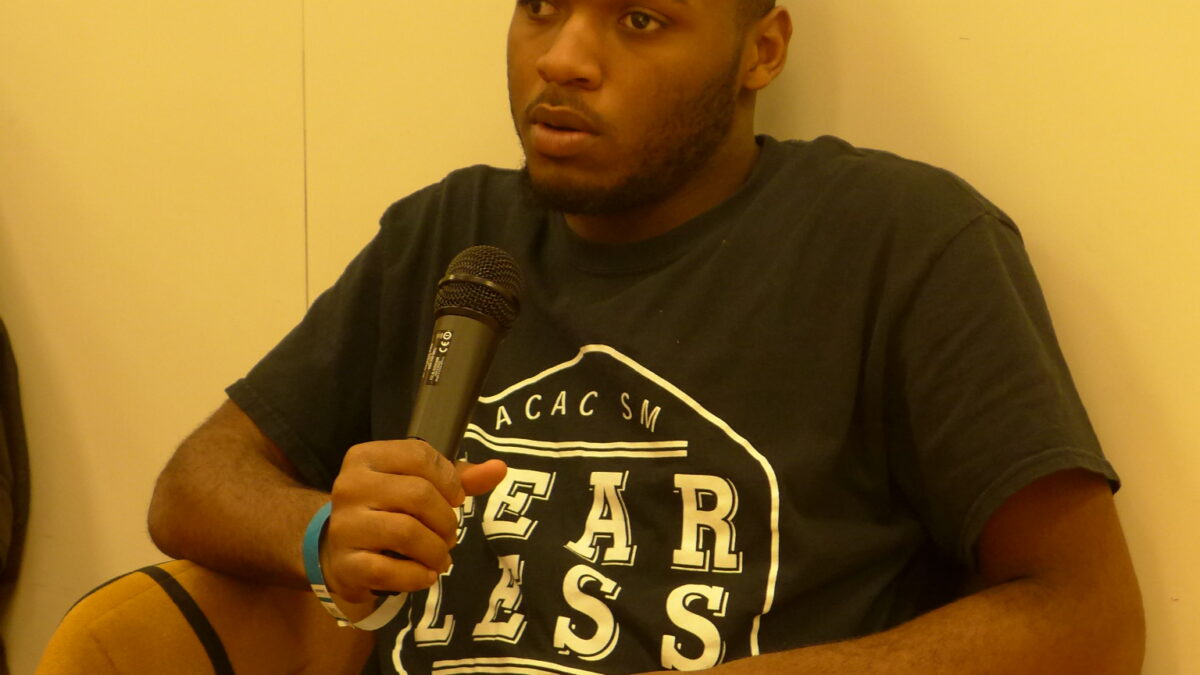 A teen holding a microphone in a classroom