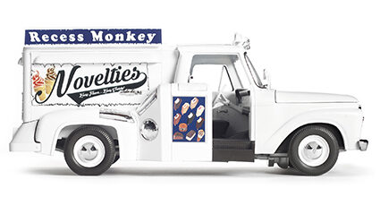 A white truck with the text "Recess Monkeys" in white on a blue background and "Novelites" on the truck in dark blue cursive font