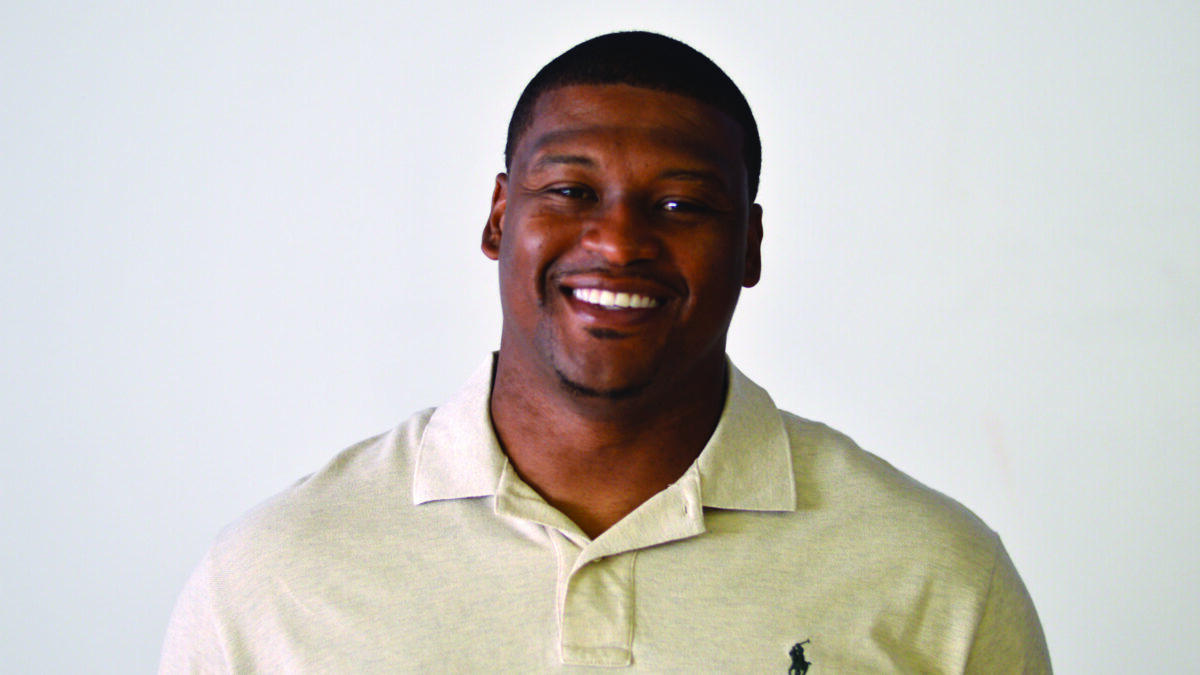 An adult wearing a white shirt smiling in profile
