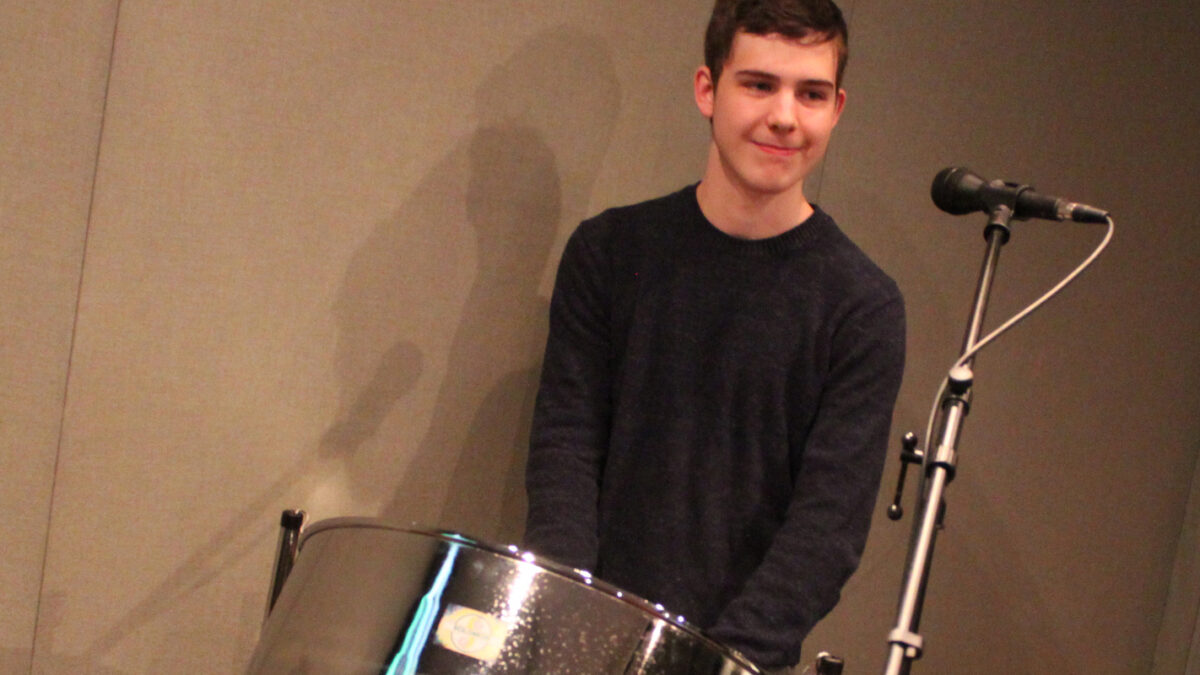 IMG_0557 A teen standing behind a steel drum in a radio studio