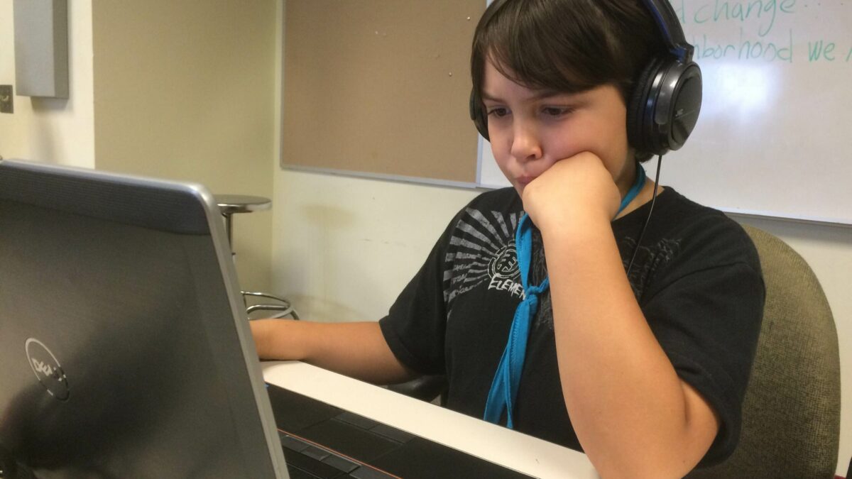 IMG_3125 A youth wearing headphones looking at a laptop computer