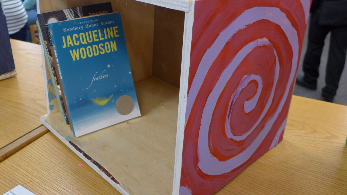 A red box with a white spiral painted on containing books in a library