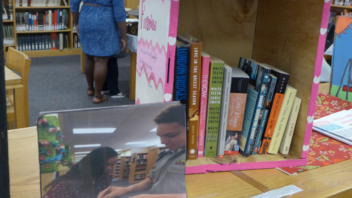 A pink wooden box containing books in a library