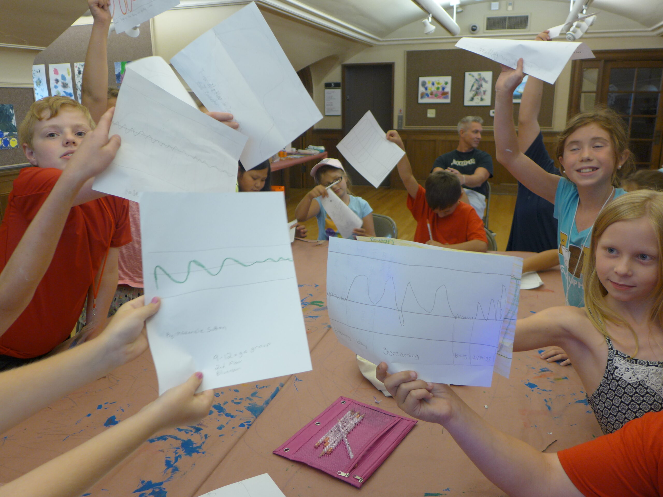 Youth holding up five pieces of paper to the camera