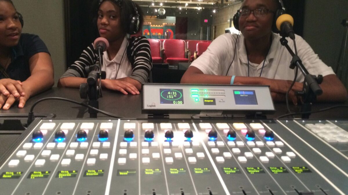 IMG_1127 Three youth wearing headphones speaking into microphones in a radio studio