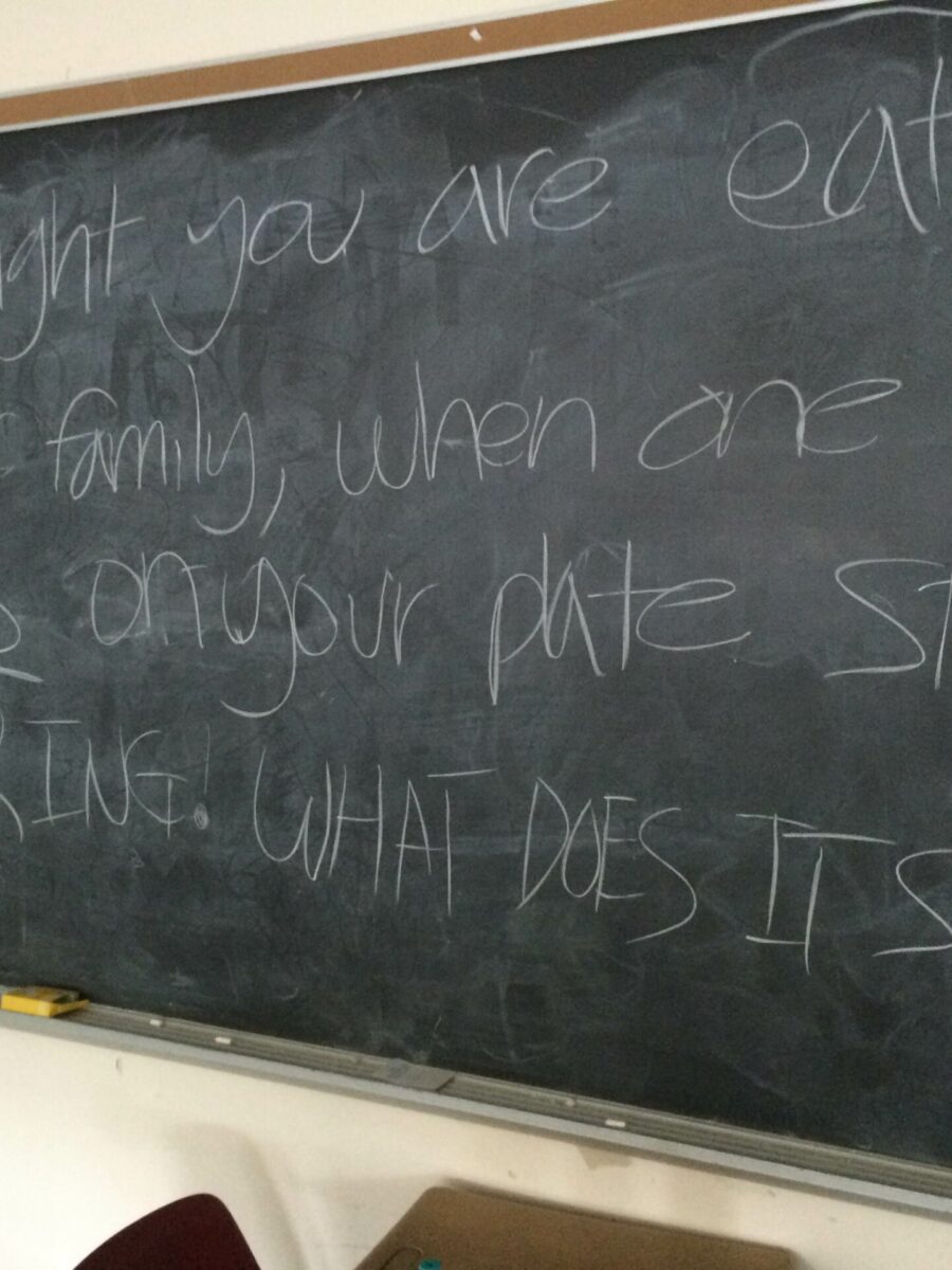 A chalkboard in a classroom reading "One night you are eating with your family, when one of the peas on your plate starts whispering. What does it say?"