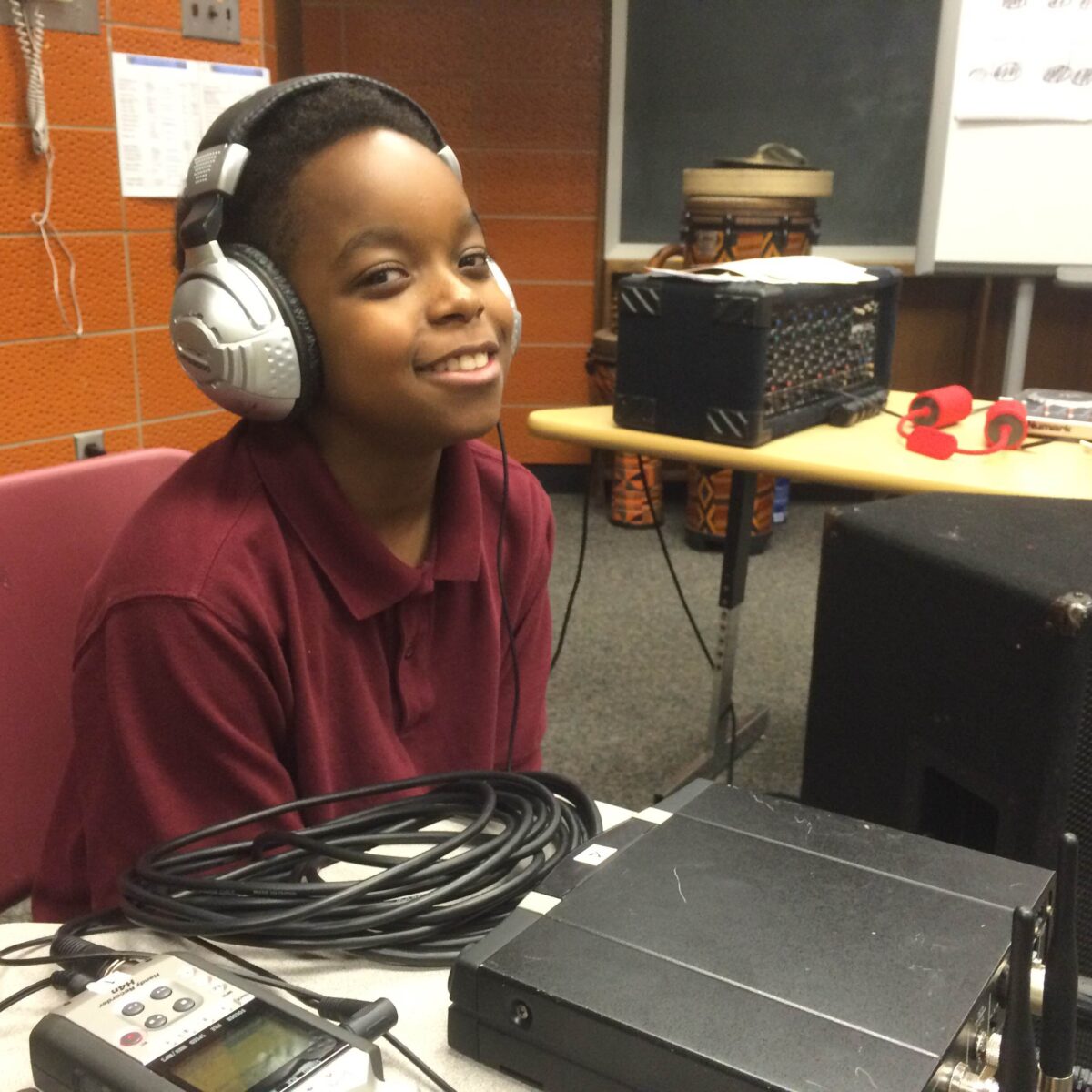 IMG_1726 A youth wearing headphones sitting behind a portable recorder on a classroom desk